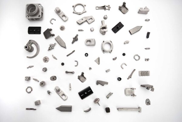 An assortment of various metal parts and components arranged randomly on a white background.