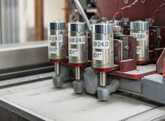 Precision machinery with multiple cylindrical components labeled at 24v, engaged in industrial manufacturing.