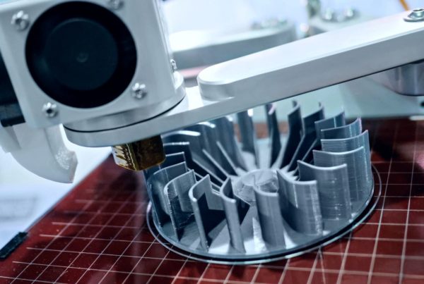 3d printer creating a detailed plastic turbine component, with the print head in focus and the object in partial view.