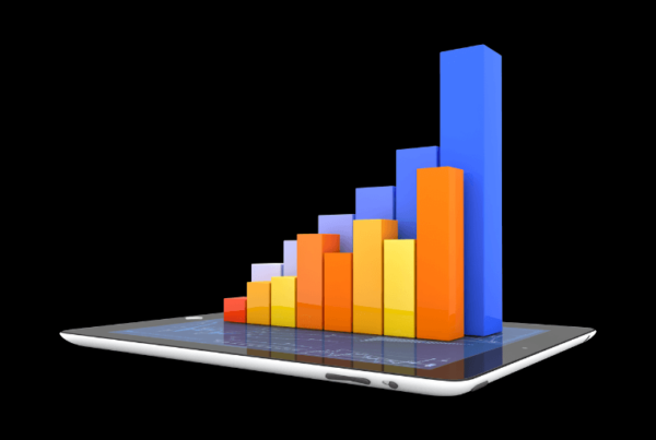 A tablet displays a colorful 3D bar chart with multiple vertical bars in different colors, illustrating data growth.