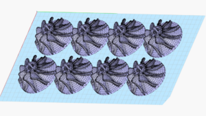 3D rendering of eight identical mesh apple models, optimized through design for additive manufacturing, arranged in a grid pattern on a light blue grid background.