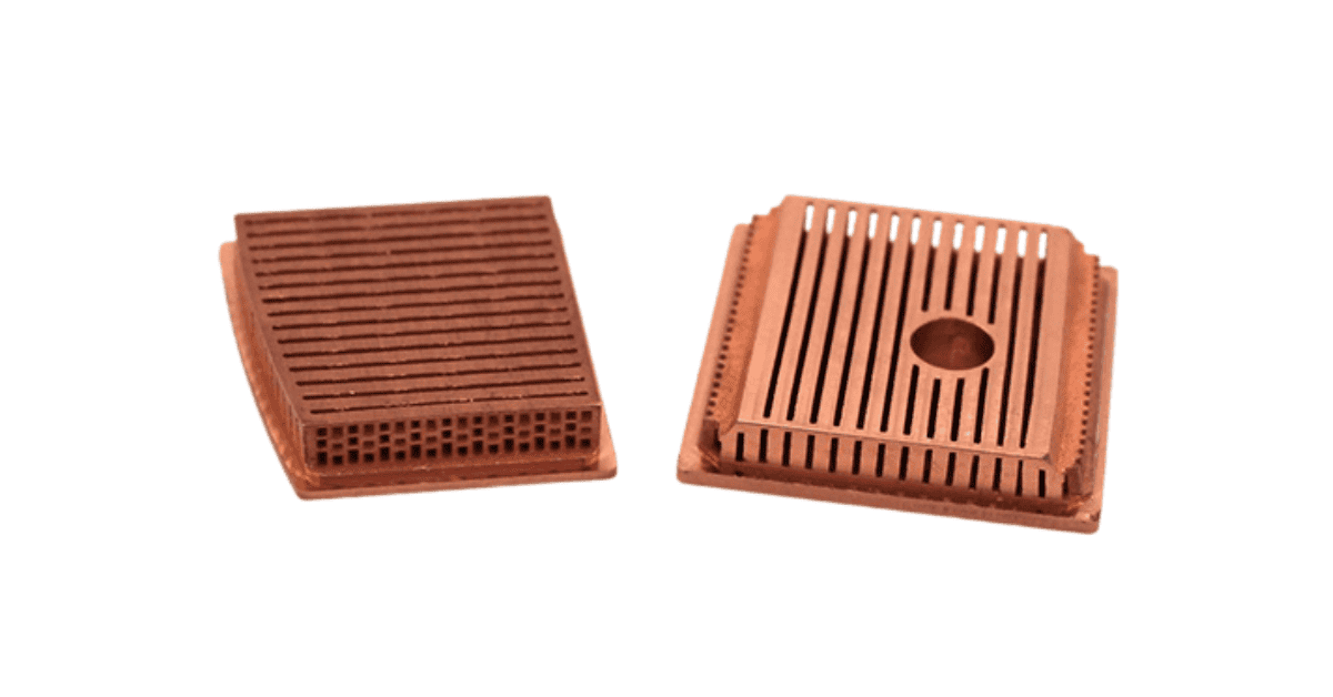 Two copper heat sinks with grooved and slotted surfaces, placed side by side on a white background, showcasing design excellence.